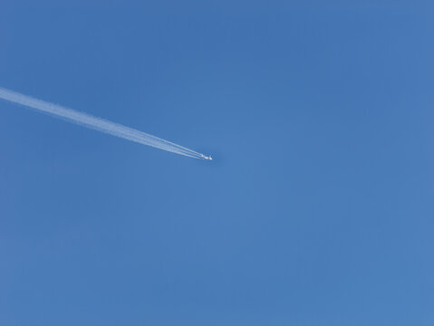 Photo of a plane leaving trails in the clear blue sky