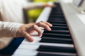Fototapeta premium Child practicing on the modern electric piano at home. Music lesson. Close-up.