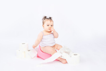 baby on a green potty with toilet paper on a white insulated background, space for text