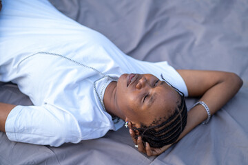 A queer masculine black woman lying down at the park	