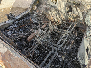 Car after the fire. Iron parts of burnt out car. Completely burnt passenger car due to accident, bad technical condition, breakdown