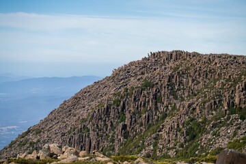 peak of a rocky mountain in a national park looking over a city below, mt wellington hobart...