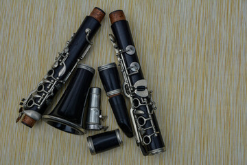 Naklejka premium The black clarinet was dismantled in parts against a yellow background.