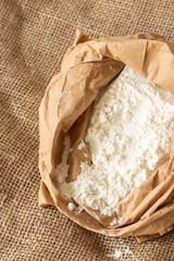 Plain white flour in a brown paper bag on hessian sack cloth. Eco friendly biodegradable recycle packaging