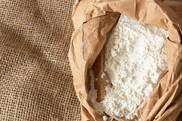 Plain white flour in a brown paper bag on hessian sack cloth. Eco friendly biodegradable recycle packaging