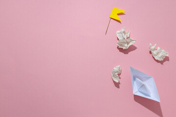 Concept of difficulties on the way to the goal with paper boat