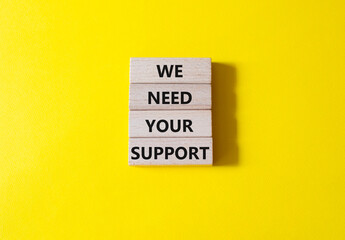 We need your support symbol. Wooden blocks with words We need your support. Beautiful yellow background. Business and We need your support concept. Copy space.