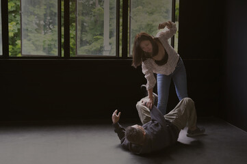 the angry female victim fights back the robber who fell to the ground in abandoned house