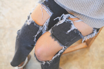 torn pants , torn jeans, close up girl wear jean - women knees in jeans holes in jeans, fashion...