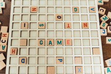 Scrabble tiles scattered on the wooden table - Game word spelled out from tiles. High quality photo
