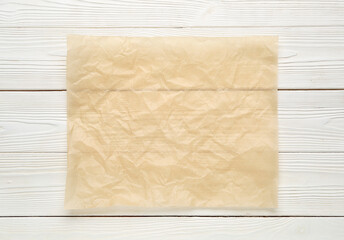 Sheet of baking paper on light wooden background