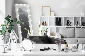 Interior of light makeup room with table, mirror and sofa