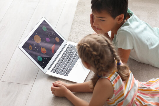 Little boy and girl watching cartoons on laptop at home