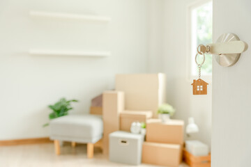 Moving house, relocation. The key was inserted into the door of the new house, inside the room was a cardboard box containing personal belongings and furniture. move in the apartment or condominium