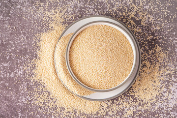 Bowl of amaranth seeds on grunge background
