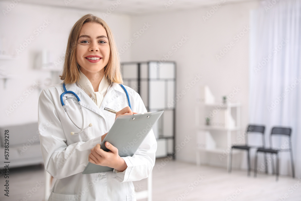 Wall mural Female doctor with clipboard in modern clinic