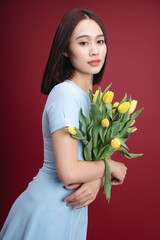 Image of young Asian woman holding tulips flowers on background