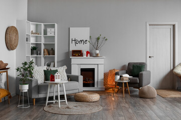 Interior of living room with fireplace, tables and house candle holders