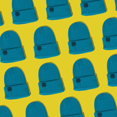 Demi-season blue ribbed knitted hat pattern background. Winter new stylish knitted wool headwear blue hat on yellow.