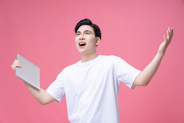 Young Asian man holding laptop on background