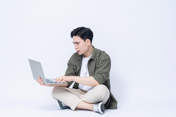 Young Asian business man sitting and using laptop on background