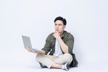 Young Asian business man sitting and using laptop on background