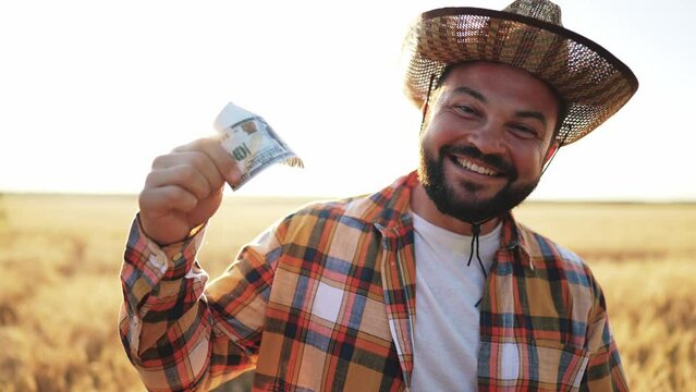 Successful man profit. Happy rich businessman farmer in straw hat holding in hands and counting stack of bills of money. Agribusiness. Male laughing and toothy smile. Earn cash farming concept.