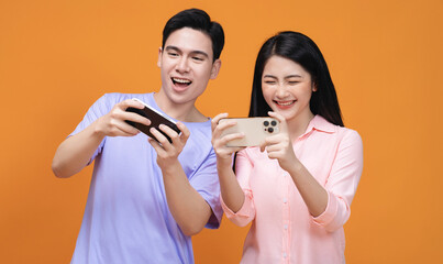 Young Asian couple using smartphone on background