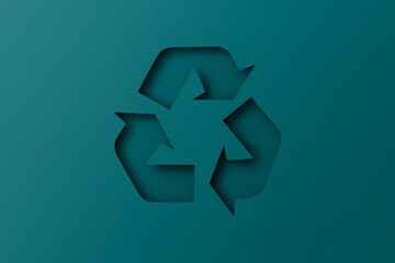 Green paper punched cut into recycled shapes isolated on green paper background.