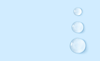 Fototapeta na wymiar round drops of transparent gel serum on blue background