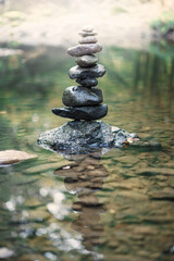 Obraz na płótnie Canvas zen,stack of stones balancing on top in blue water of the river