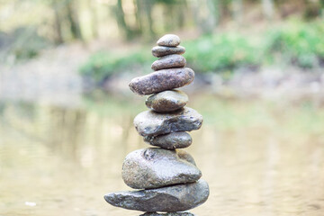 zen,stack of stones balancing on top in blue water of the river
