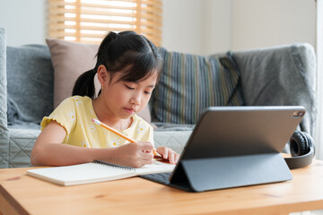 Asian little girl doing homework, learning, student using digital tablet.  - 573839007