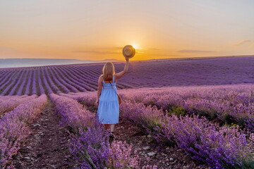 Woman lavender field sunset. Romantic woman walks through the la