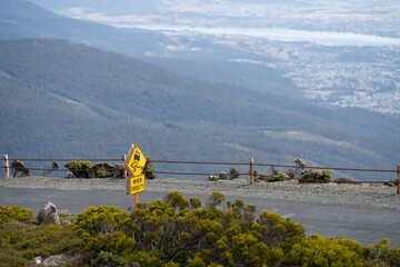 peak of a rocky mountain in a national park looking over a city below, mt wellington hobart...