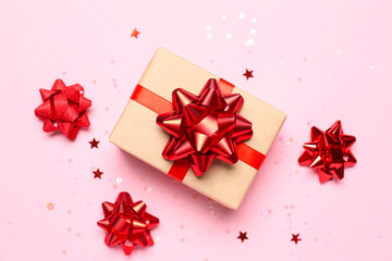 Gift box with red bows and stars on pink background