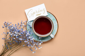 Cup of tea, card with word SPRING and gypsophila flowers on color background