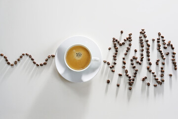 Coffee beans in a calm curve lead to a coffee cup, afterwards the beans show an exited messy...