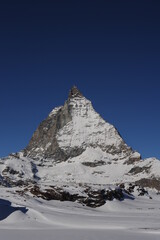 Matterhorn mountain peak  in Alps in winter with snow and clear blue sky in Cervinia, Italy and Zermatt, Switzerland. Beautiful and magnificent landscape on a sunny day