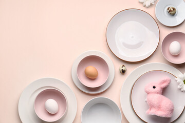 Set of plates with Easter eggs, bunny and chrysanthemum flowers on beige background