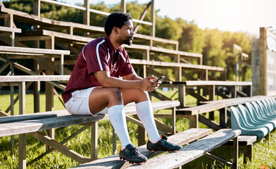 Rugby, sports or black man on pavilion thinking of training, exercise or workout game on grass field. Wellness, focus or African athlete with a vision, motivation or fitness goals sitting on a bench