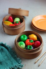 sweet steamed cakes shaped like fruit in a bamboo steamer
