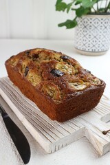 Banana and date cake ready to be cut on a wooden tray