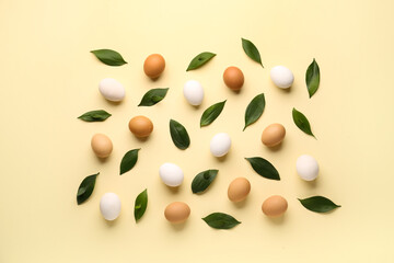 Composition with Easter eggs and green leaves on beige background