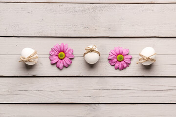 Fototapeta na wymiar Easter eggs and chrysanthemum flowers on grey wooden background