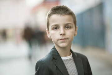 Fototapeta premium elegantly dressed handsome boy standing and walking the streets of the city
