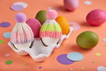 Colored Easter eggs decorated with hats. Spring greeting card banner with traditional Easter symbols. 