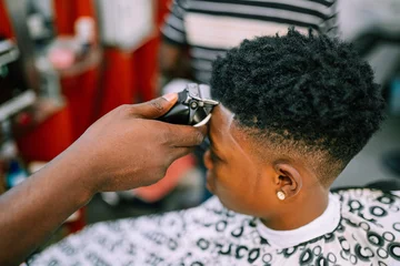Tuinposter A young queer masculine woman getting a haircut © Ajay Abalaka