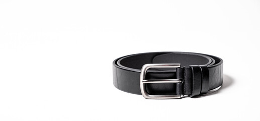 Black leather belt for trousers and jeans. Fastened fashionable men leather belt with dark chrome matted metal buckle isolated on white background. Male accessory. Luxury strap. Haberdashery goods