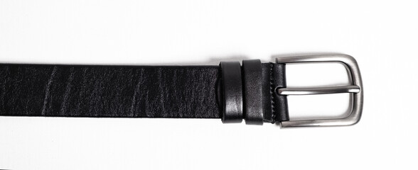 Black leather belt for trousers and jeans. Fastened fashionable men leather belt with dark chrome matted metal buckle isolated on white background. Male accessory. Luxury strap. Haberdashery goods